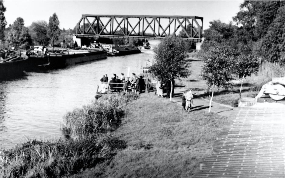 Foto: Warten auf die Fähre, um 1955. Im Hintergrund die Eisenbahnbrücke. Archiv B. Becker